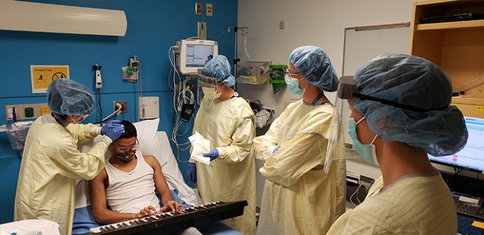 Irene and the care team prepare to access Malachi&rsquo;s port for treatment. Malachi loves playing the piano; he&rsquo;s pictured here using his seven-hour brain infusion treatment session to practice.