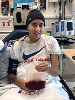 Jedd holds a bag containing his reprogrammed T cells during cancer immunotherapy treatment at Seattle Children&rsquo;s