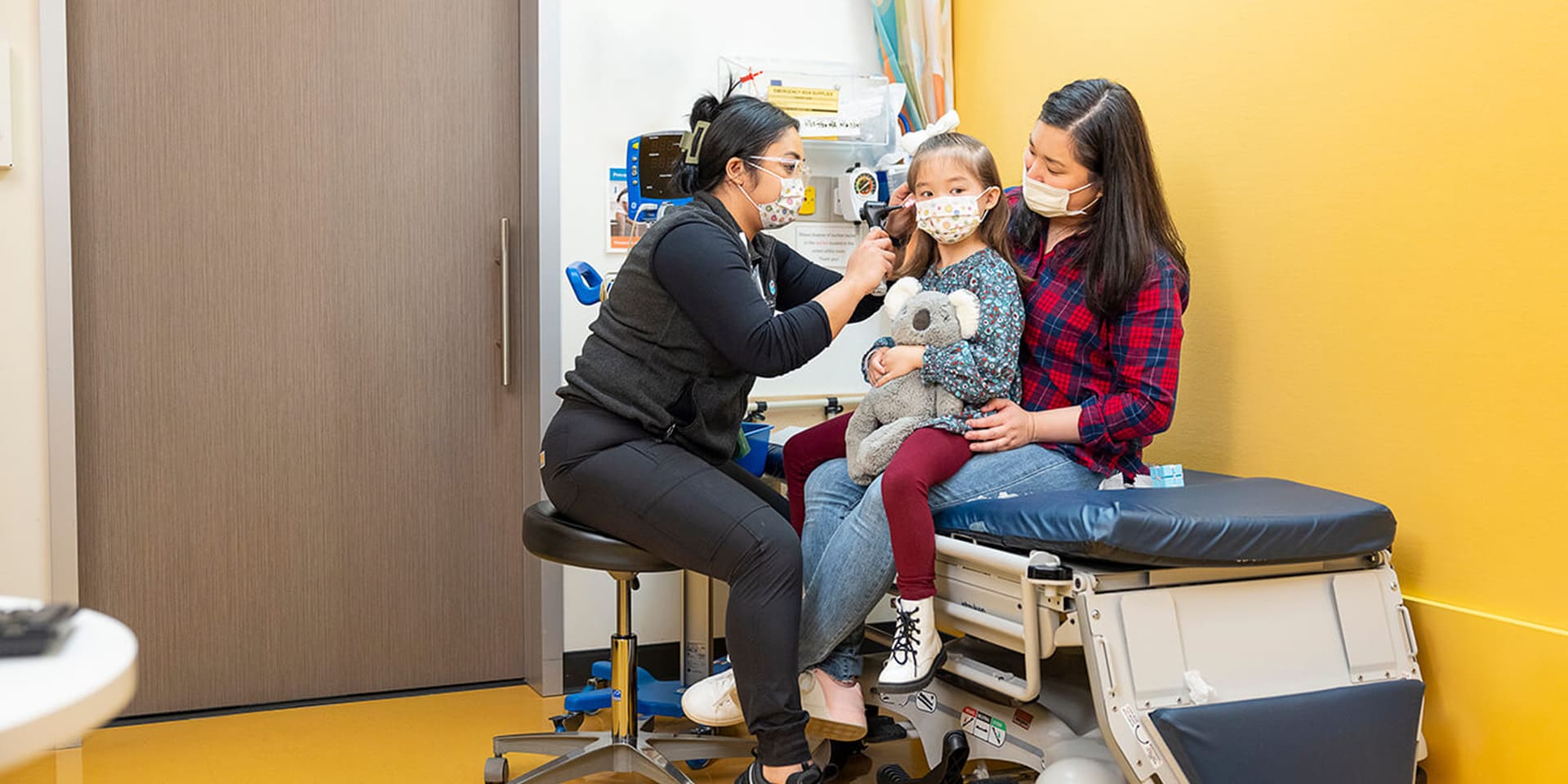 Child in her mother's lap during a doctor's exam