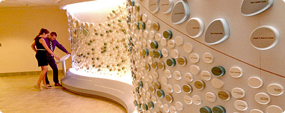 Visitors read about the river rock donor wall display at Seattle Childrens