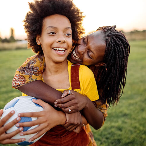 Mother holding son and soccer ball