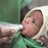 A baby using a NIFTY cup