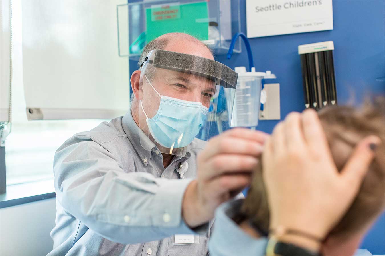 Dr. Ojemann examines a young patient's head at Seattle Children's Brain Tumor Program 