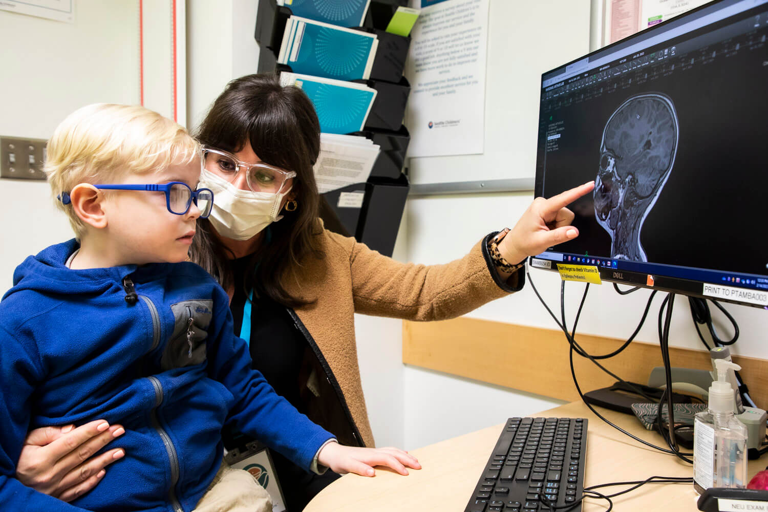 Child and provider pointing at a computer screen