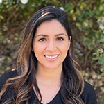 A closeup photo of Araceli Mendez Sanchez smiling while standing in front of a tree