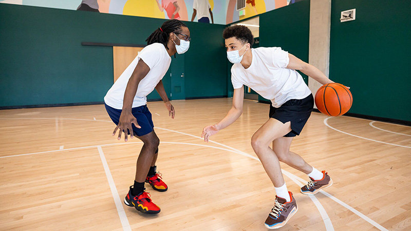 Two teen boys playing one-on-one basketball