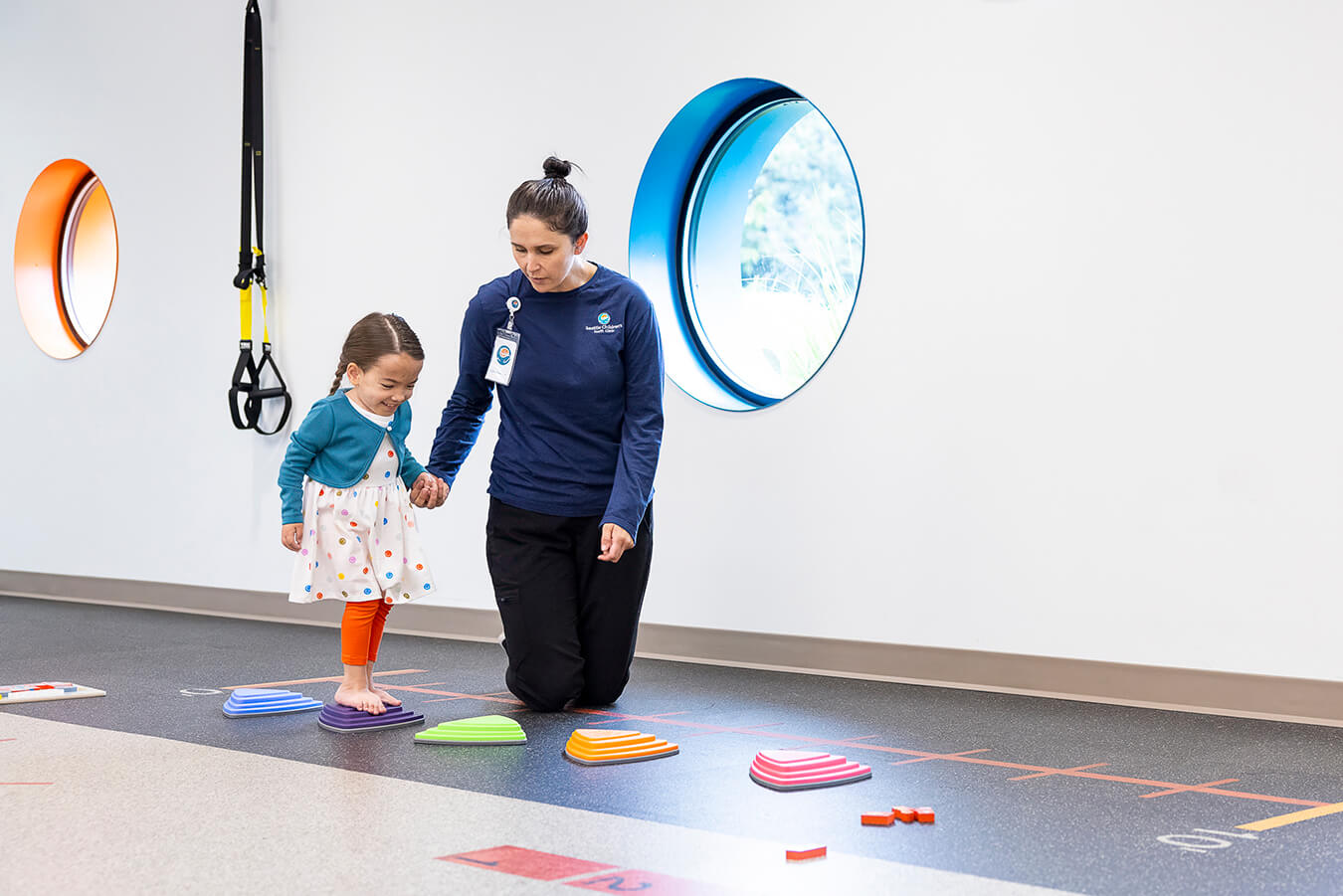 A child practices walking with a physical therapist
