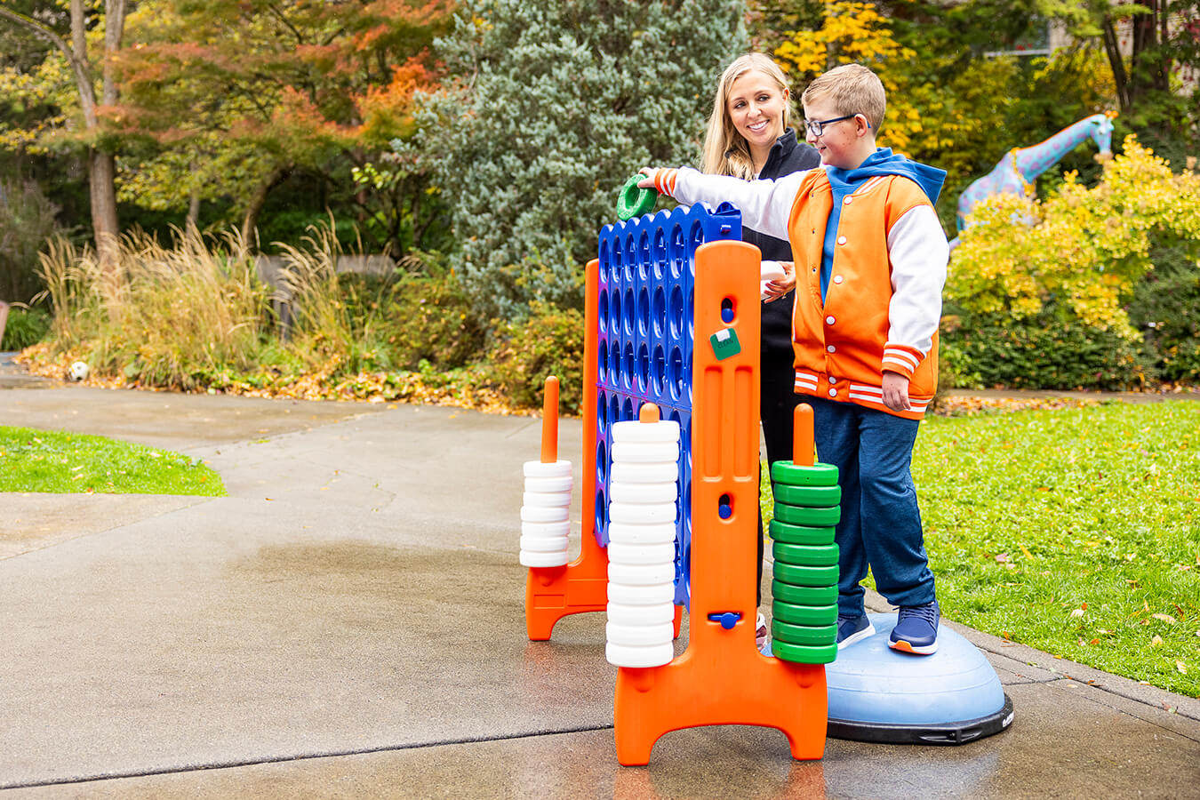 An adult and child play a game outdoors