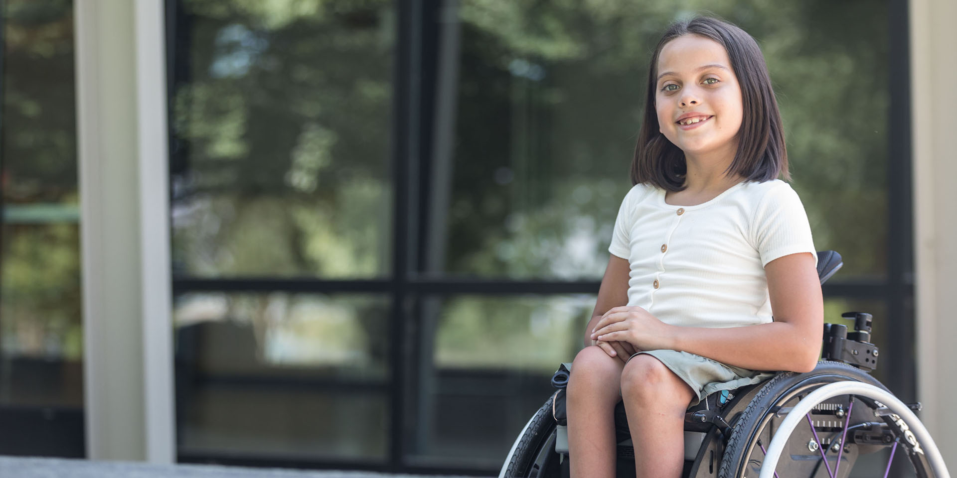 A girl sits in a wheelchair 