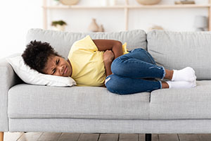 A girls lies on her side on a couch.