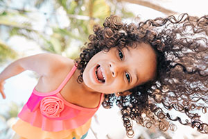 A girl in a bathing suit looks down at the camera