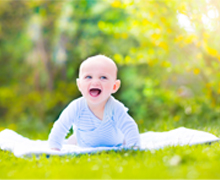 A baby on a blanket outdoors