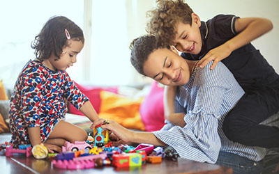 A mother plays with her son and daughter