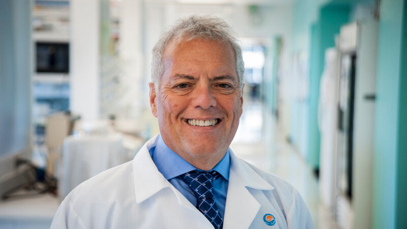 Dr. Michael Portman smiling at the camera whiles standing inside a Seattle Children's lab.