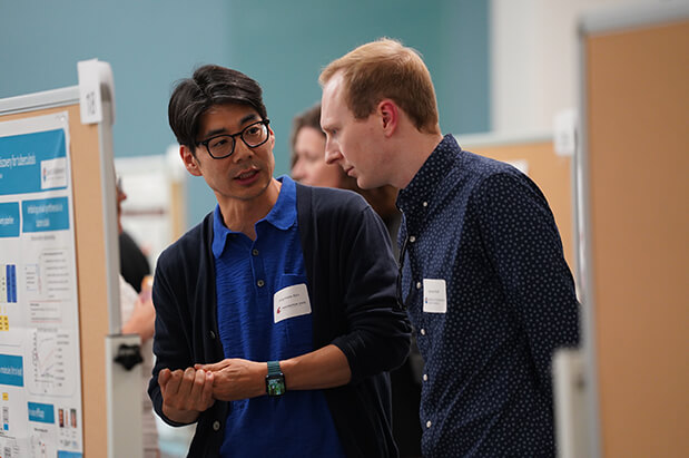 Two male researchers from Seattle Children&rsquo;s and Washington State University discuss a scientific poster